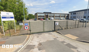 A graphic design of red, black and cream, with arrows, a pound sign and a hand holding three credit cards.