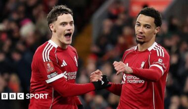 Adam Phillips of Barnsley scores past Giorgi Mamardashvili of Liverpool as teammate Dominik Szoboszlai reacts after making a defensive error.