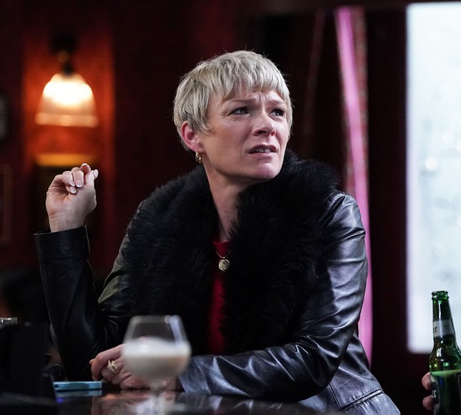 Nicola Mitchell at the bar in the Queen Vic pub in EastEnders, looking unimpressed.