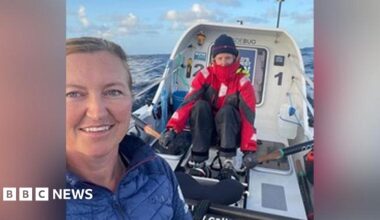 Emma Wolstenholme and a crew member on board their small rowing boat. She is in blue while her colleague wears a red overcoat and beanie hat