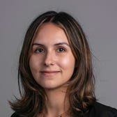 Julia Pugachevsky's face on a gray background.