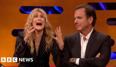Laura Dern, in a black striped jacket, gestures with her mouth open and hands raised. Will Arnett looks on next to her