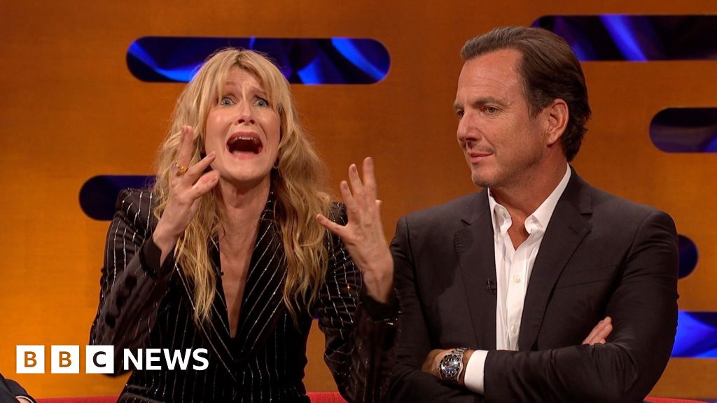 Laura Dern, in a black striped jacket, gestures with her mouth open and hands raised. Will Arnett looks on next to her