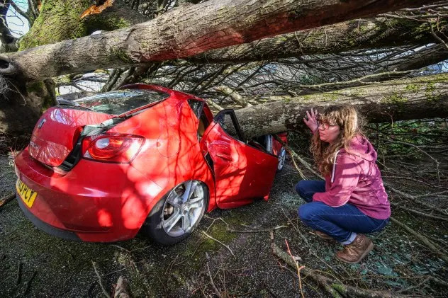 Falmouth University student Anna Richmond inspects the damage to her car which was crushed outside her rented accommodation by fallen trees during Storm Goretti on Jan. 09, 2026 in Falmouth, England. (Photo by Hugh Hastings/Getty Images)