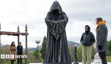 A giant cloaked chess piece with celebrities looking on on The Celebrity Traitors