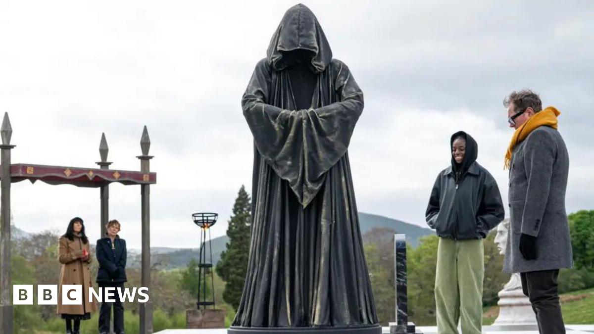 A giant cloaked chess piece with celebrities looking on on The Celebrity Traitors