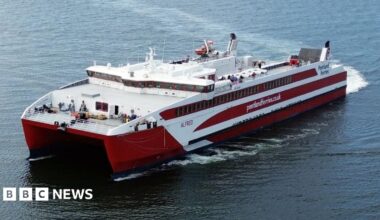 A red and white catamaran ferry with Pentland Ferries written on the side