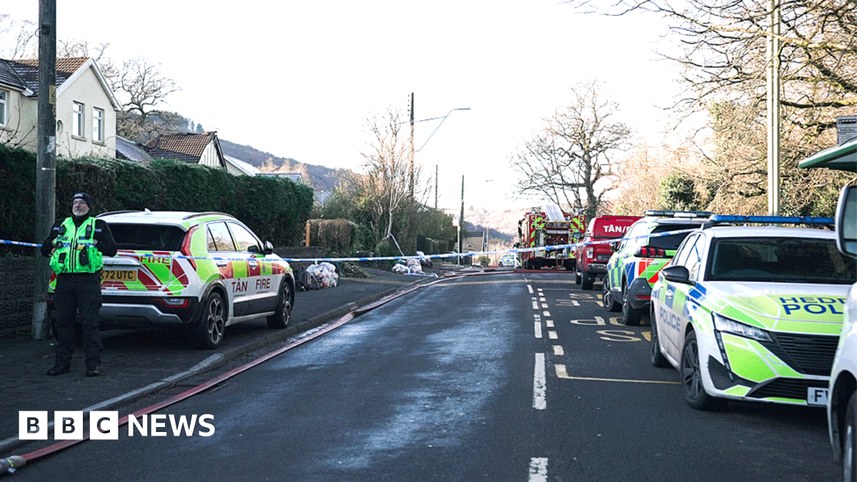 A police cordon has been put across a residential road, with emergency services vehicles parked at the scene