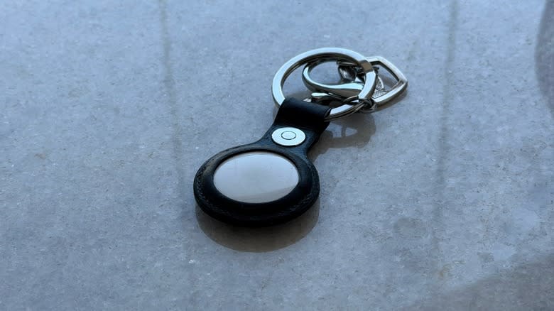Apple's AirTag item tracker with its keychain accessory attached.