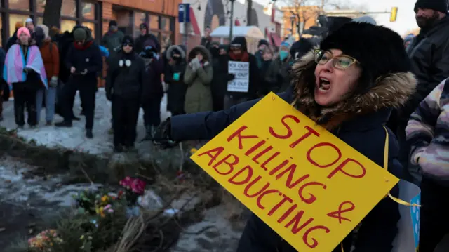 People gather around a makeshift memorial at the site where a man was fatally shot by federal agents trying to detain him, in Minneapolis, Minnesota