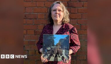Emma Bowden holding a copy of Abbey Road by The Beatles on vinyl.
