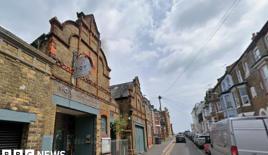 A brick building on a terraced, residential street. The signage on the building reads TCY.