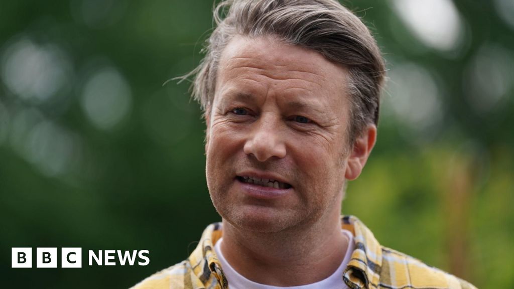 Jamie Oliver - head and shoulder image. He is wearing a yellow and grey checked shirt.