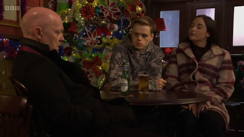 eastenders max oscar and lauren branning all sat at a table in the queen vic