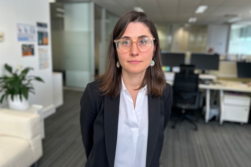 A lady in a black suit in an office