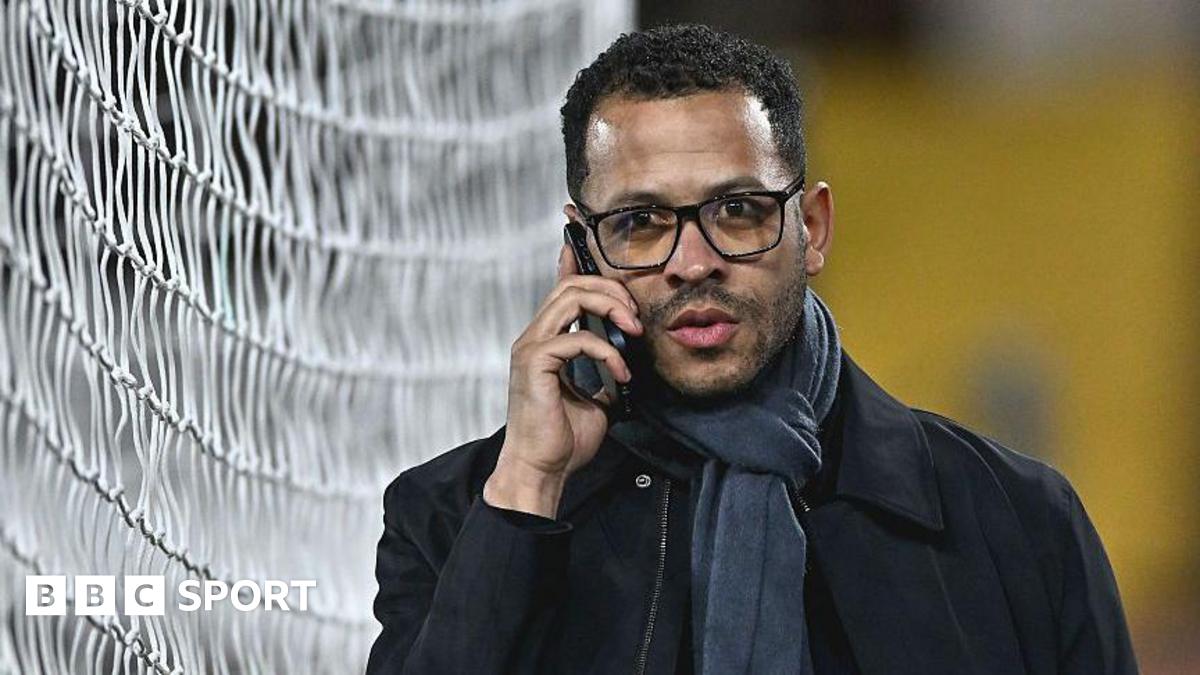 Liam Rosenior on the phone while walking next to one of the goals at Fulham