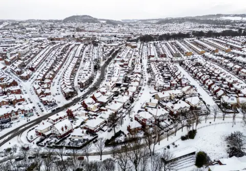 PA Media An aerial view of Scarborough, UK, covered in snow.