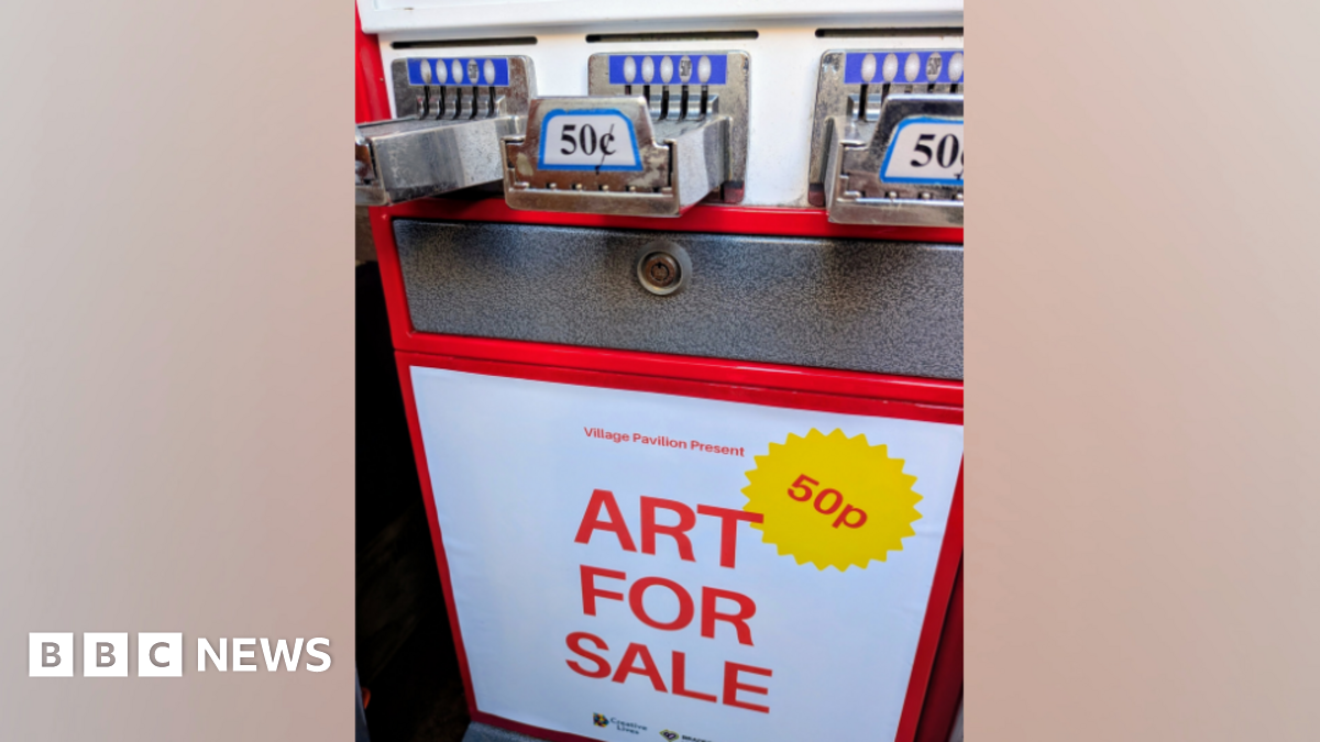 A red, white and silver vending machine with a sign which reads 'Art For Sale'. There is a yellow sticker which says '50p'.