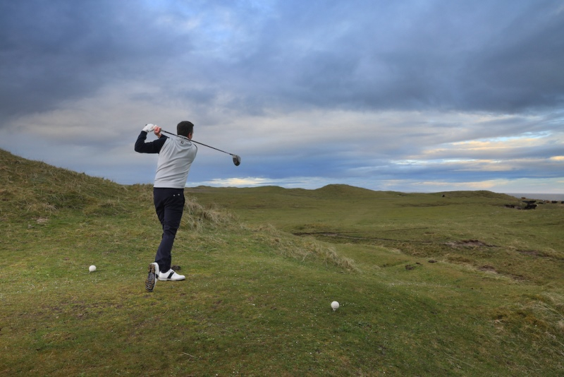 Golfer on a links course on a cold, overcast day.
