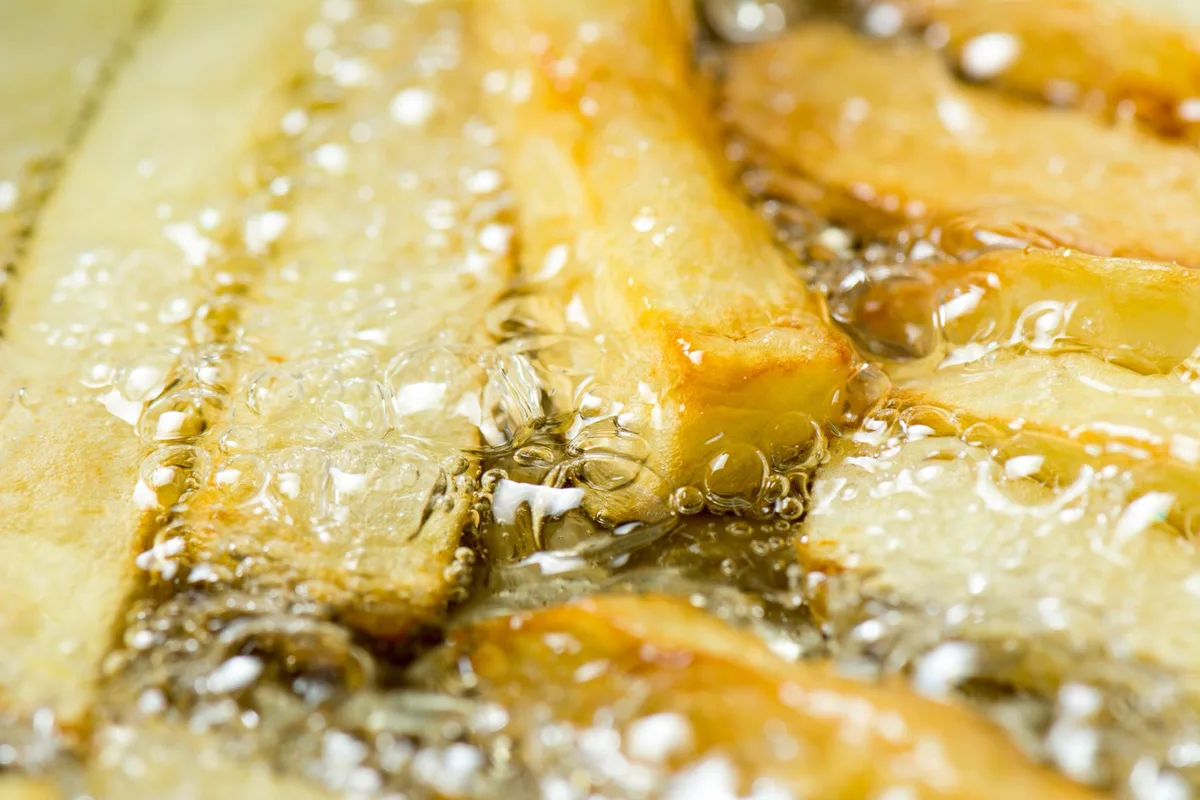 An extreme closeup of chips frying in oil.