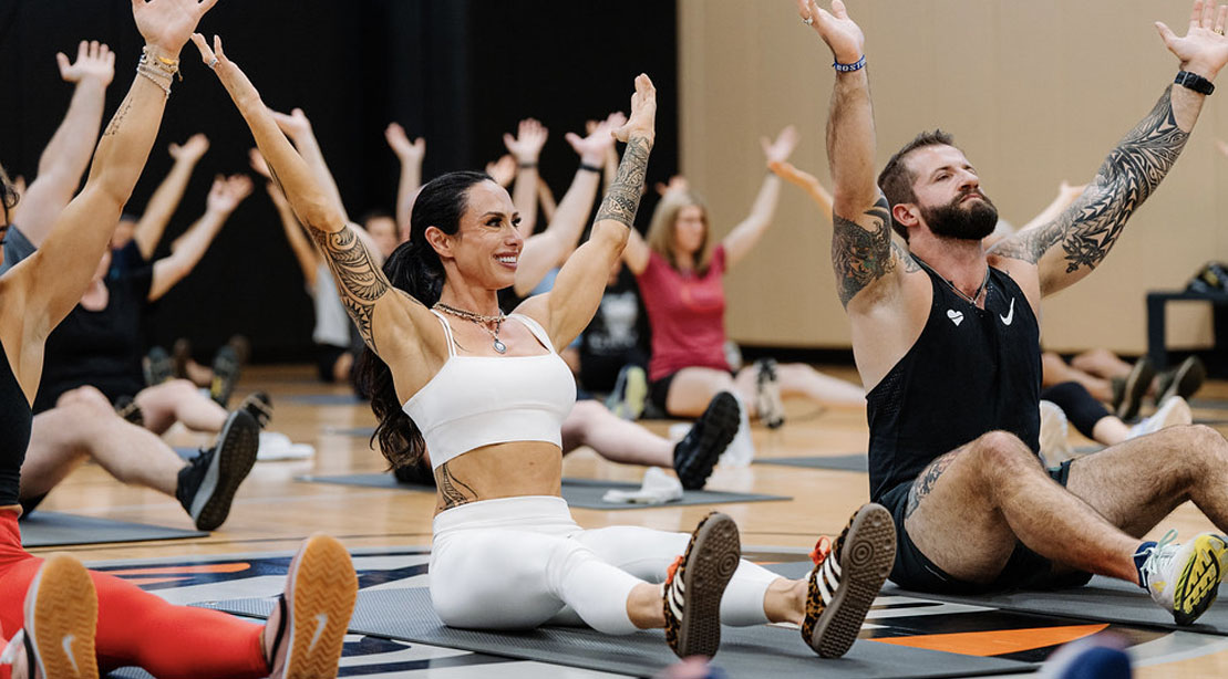 Dr. Gabrielle Lyon leading a group fitness class to stretching