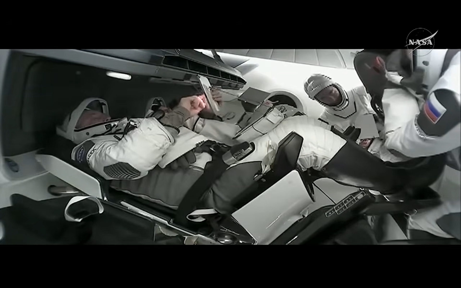 four astronauts in white pressure suits inside Crew-11 Dragon