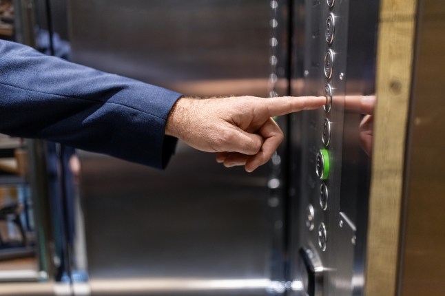 Close-up of a businessman using hotel elevator