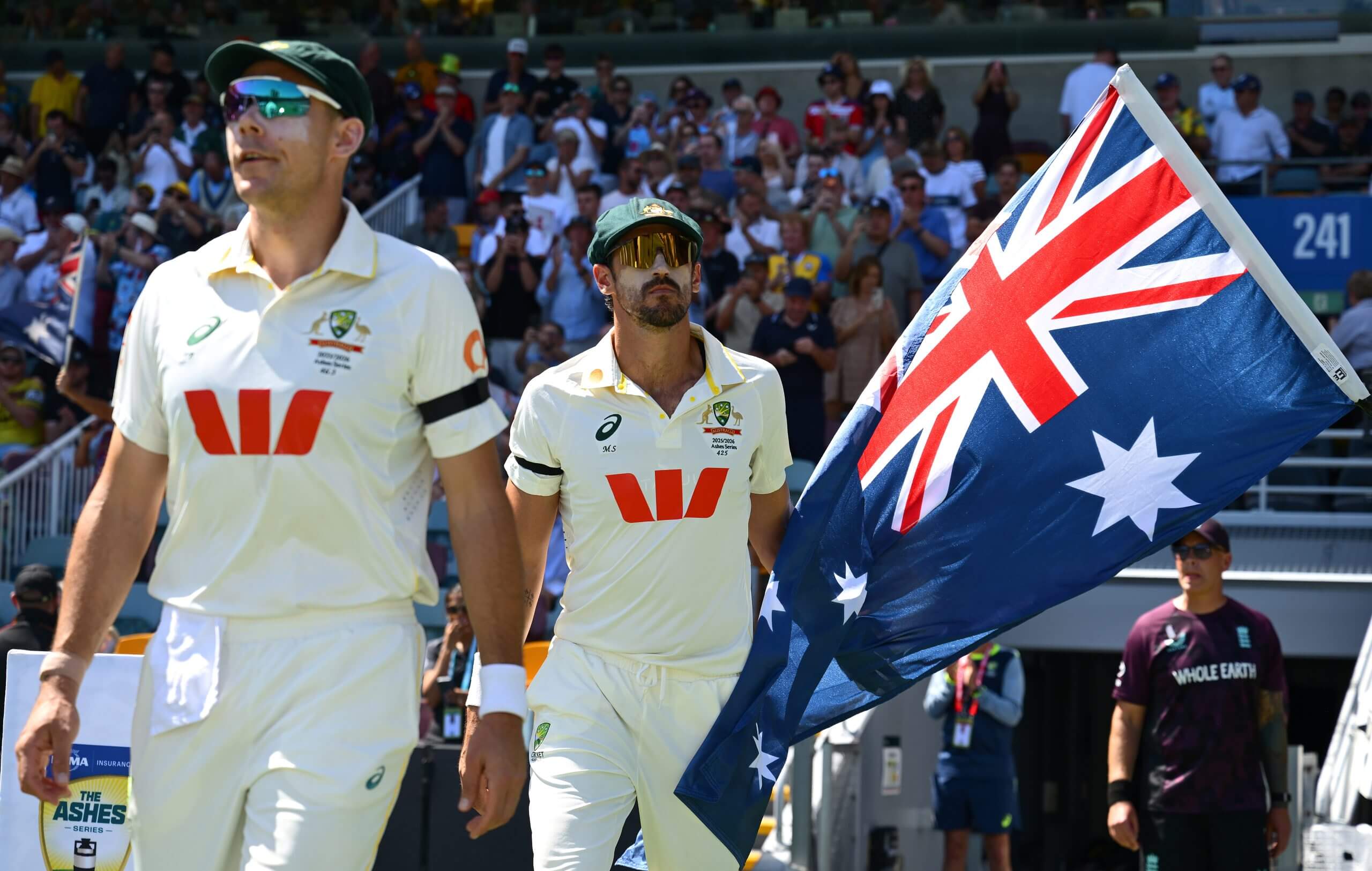 Scott Boland and Mitchell Starc emerge into the sunlight at the Gabba