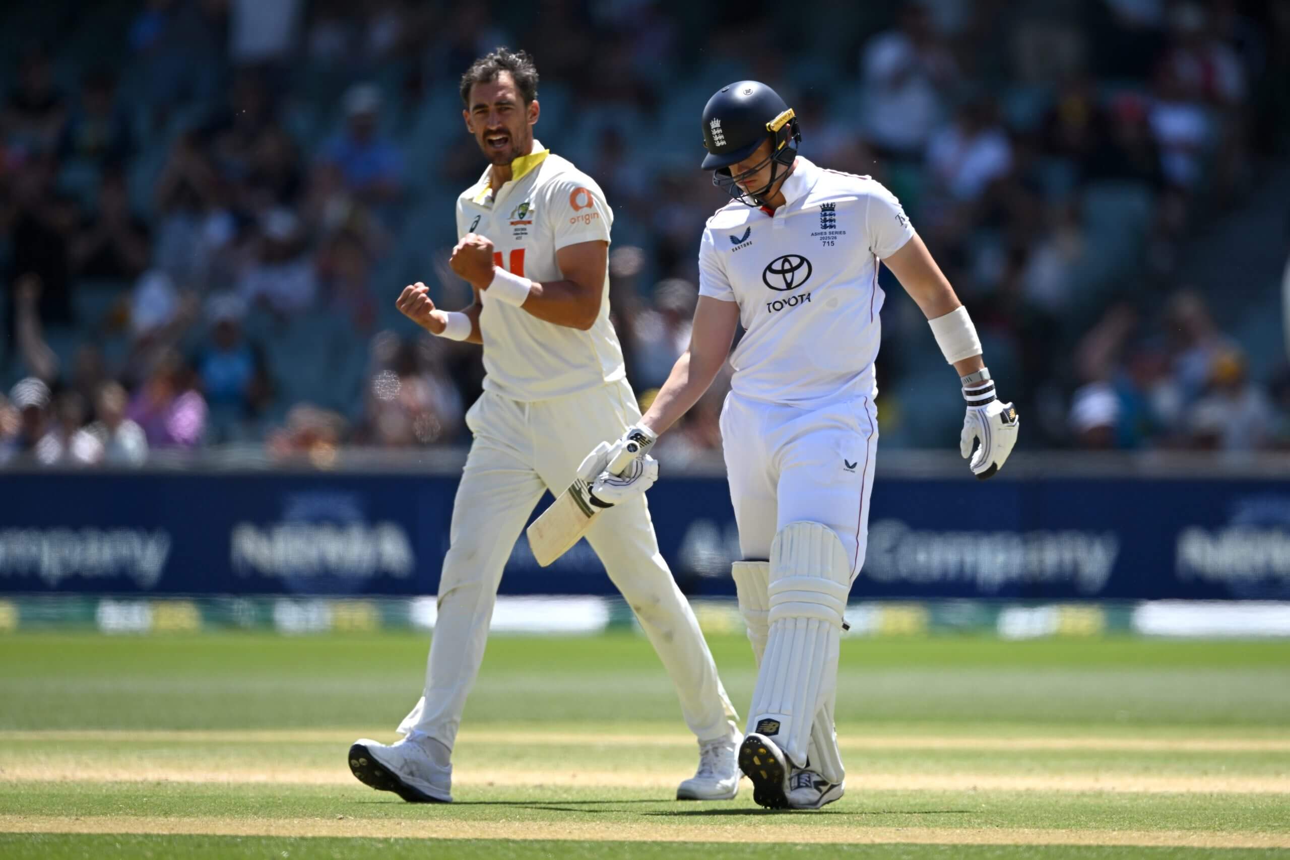 Mitchell Starc celebrates while Jamie Smith practises the shot he had been attempting to play