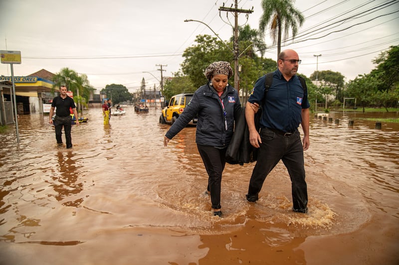 People wade through a flooded street in Porto Alegre, Rio Grande do Sul State, Brazil, in May 2024. Nearly 70,000 people were forced from their homes amid flooding, mudslides and torrential storms in southern Brazil, with the major city of Porto Alegre particularly hard hit. Photograph: Carlos Fabal/AFP via Getty Images