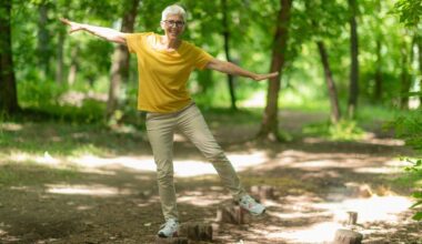 woman balances on one leg on tree stump