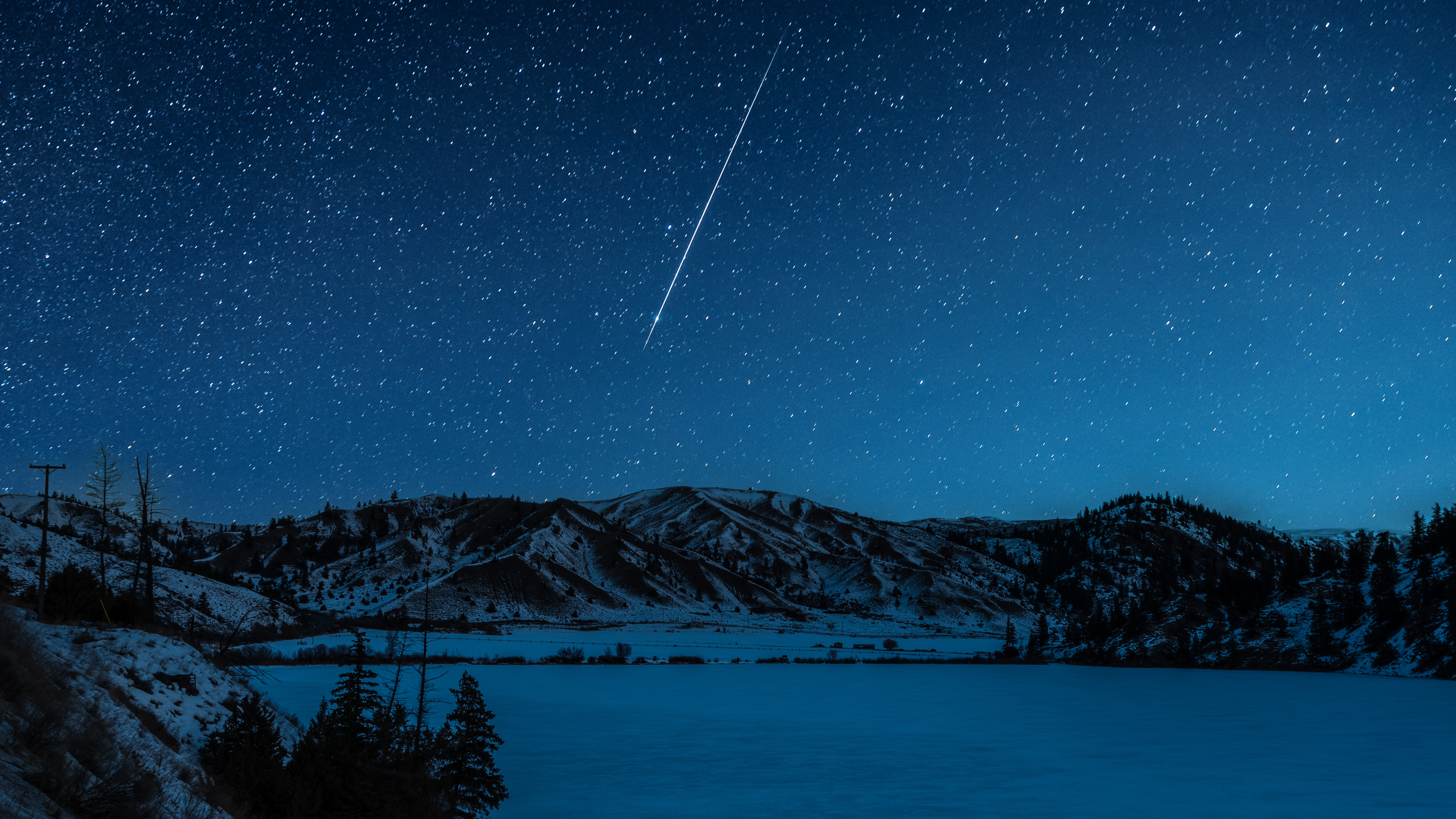 A shooting star streaks across a frozen landscape near Kamloops, BC, Canada