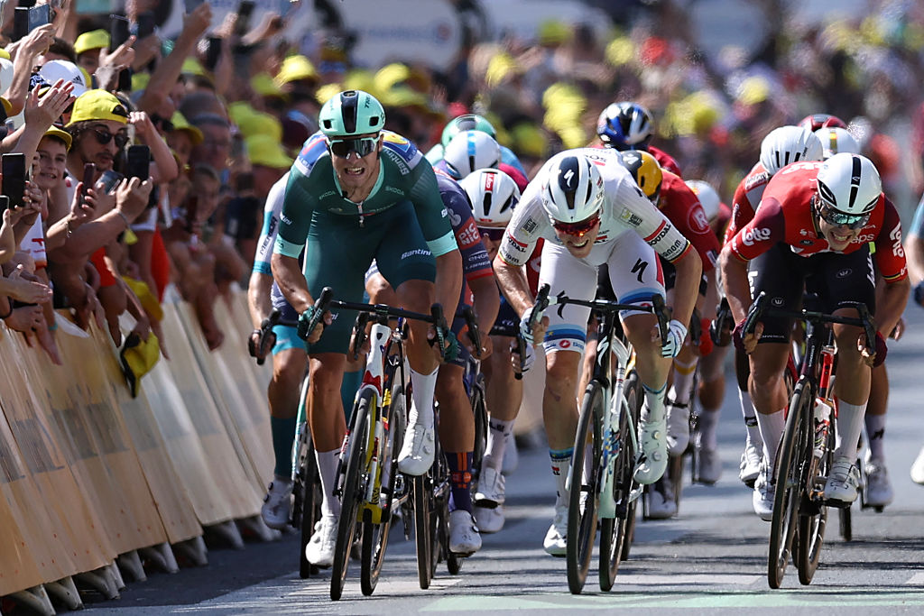 Soudal Quick-Step team's Belgian rider Tim Merlier (C) sprints to the finish line to win ahead of Lidl - Trek team's Italian rider Jonathan Milan wearing the best sprinter's green jersey (L) placing second and Lotto team's Belgian rider Arnaud De Lie placing third (R) during the 9th stage of the 112th edition of the Tour de France cycling race, 174.1 km between Chinon and Chateauroux, central France, on July 13, 2025. (Photo by Anne-Christine POUJOULAT / AFP)