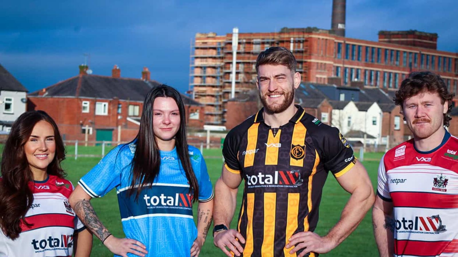 Oldham's players model their three kits for 2026 - home (red and white hoops), away (sky blue) and 150th anniversary (black and yellow stripes)