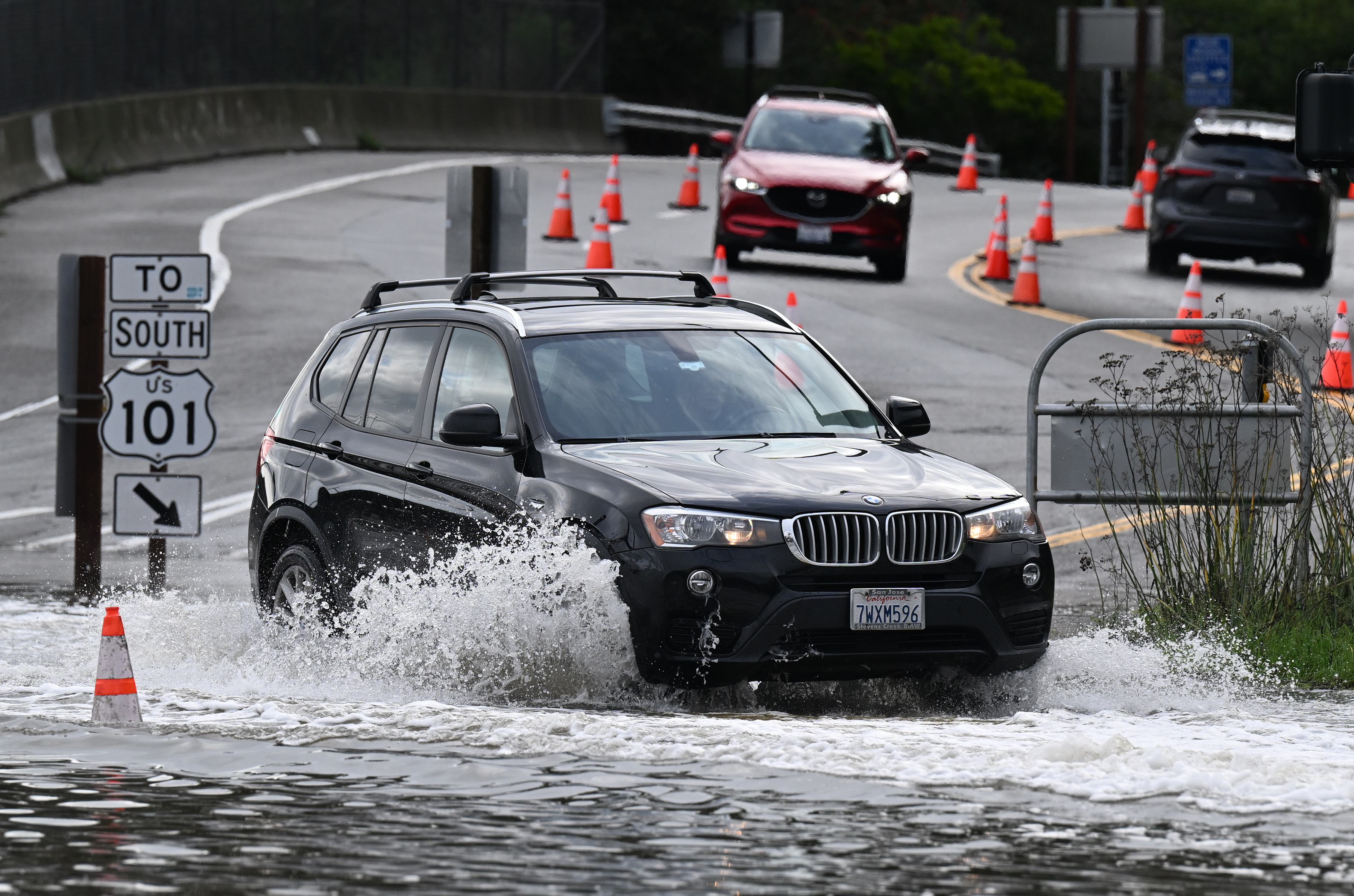 A car drives through water at the southbound Highway 101...