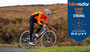 Man on 3T road bike with Rouvy themed week banner