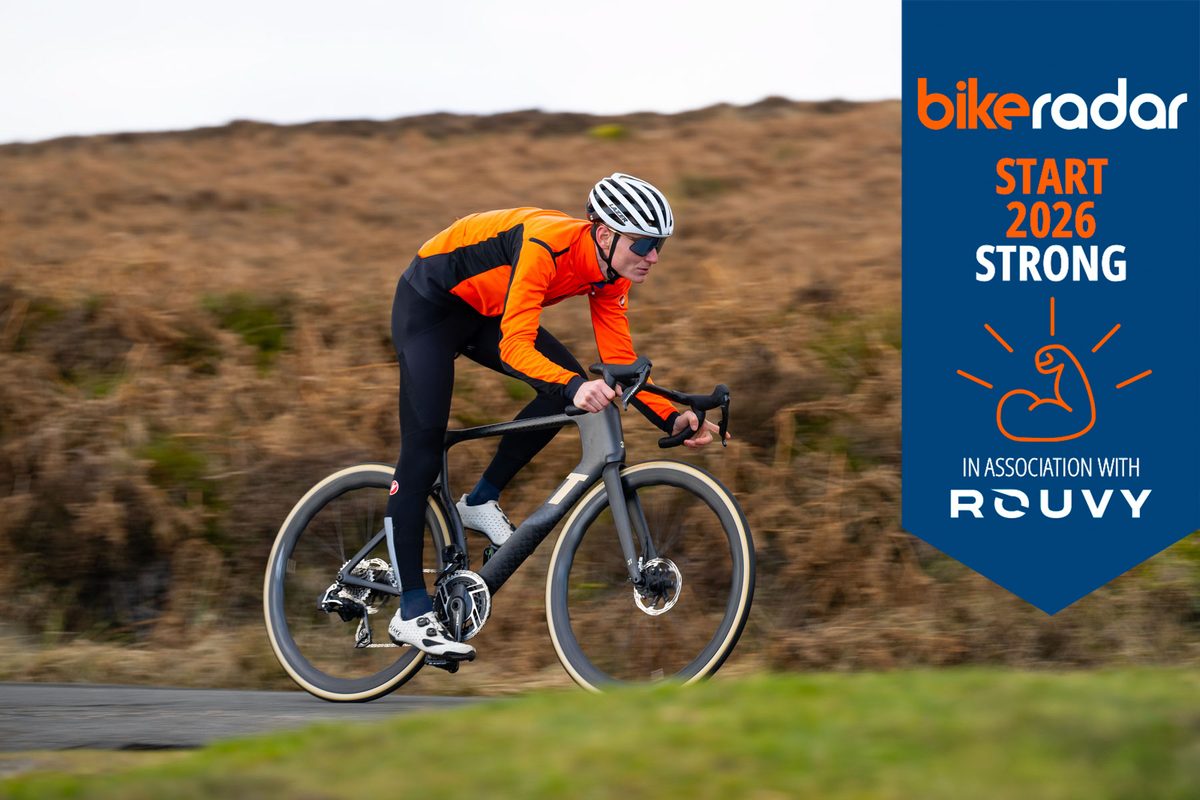 Man on 3T road bike with Rouvy themed week banner