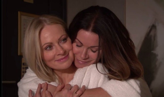 Carla hugging Lisa from behind while wearing spa robes in Corrie