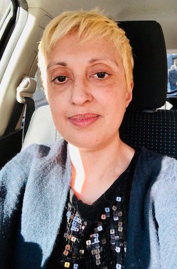 Sufia Taylor takes a selfie in the car, wearing a black cardigan and black glittery top.