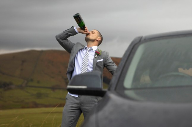 Carl standing by a car drinking some alcohol in Corrie