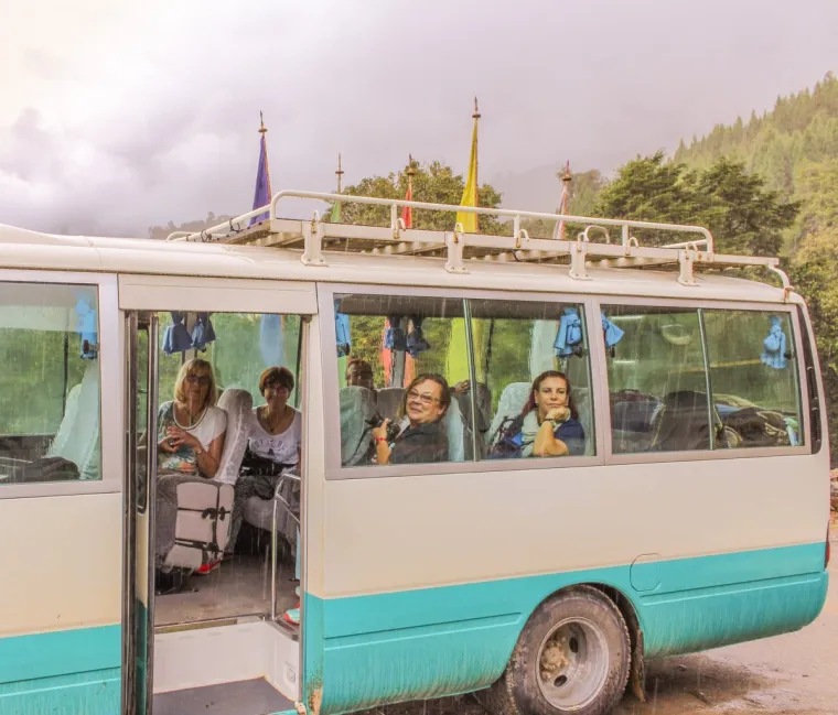 Punakha, Bhutan - September 11, 2016: Happy tourists waiting in Thimphu to Punakha bus on a rainy day