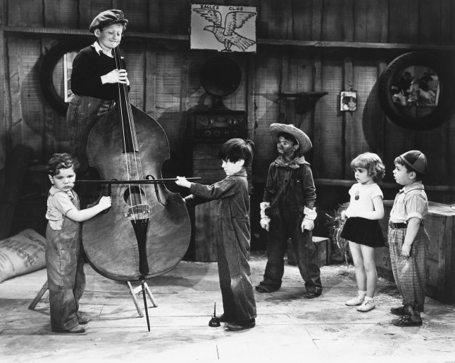 Our Gang (from left: Tommy Bond (1926-2005), US child actor, Sidney Kibrick, US child actor, Scotty Beckett (1929-1968), US child actor, Carl Switzer (1927-1959), US child actor, Darla Hood (1931-1979), US child actress, and George McFarland (1928-1993), US child actor)) playing a cello in a publicity portrait, circa 1935. Later known as 'The Little Rascals' the comedy shorts starred Bond as 'Tommy', Kibrick as 'The Woim', Beckett as 'Scotty', Switzer as 'Alfalfa', Hood as 'Darla', and McFarland as 'Spanky'. (Photo by Silver Screen Collection/Getty Images)