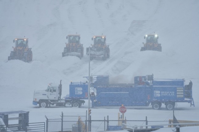 Airport crew plow snow during a winter storm in Philadelphia, Sunday, Jan. 25, 2026. (AP Photo/Matt Rourke)