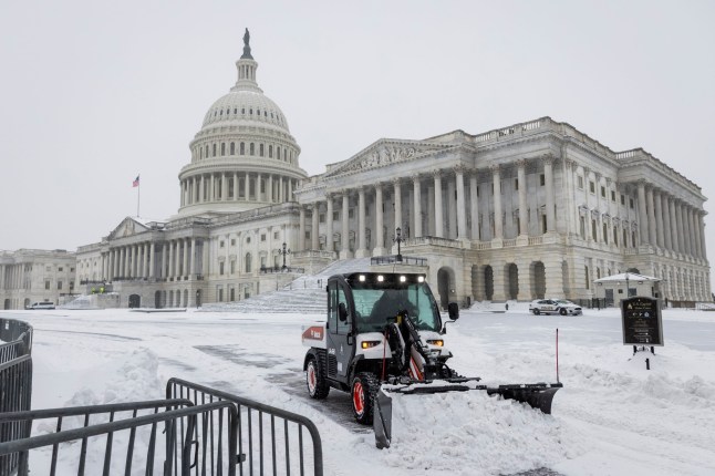 epa12680208 A Bobcat removes snow from the East Front Plaza of the US Capitol in Washington, DC, USA, 25 January 2026. The DC-area is expected to receive 5-9 inches of snow from the massive storm, which stretches across much of the US. EPA/JIM LO SCALZO