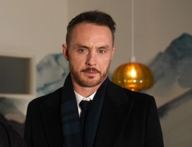 James looms behind a shocked Ste in Hollyoaks as they look at the camera