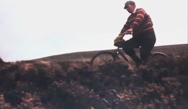 A man crosses a moor on a bike.