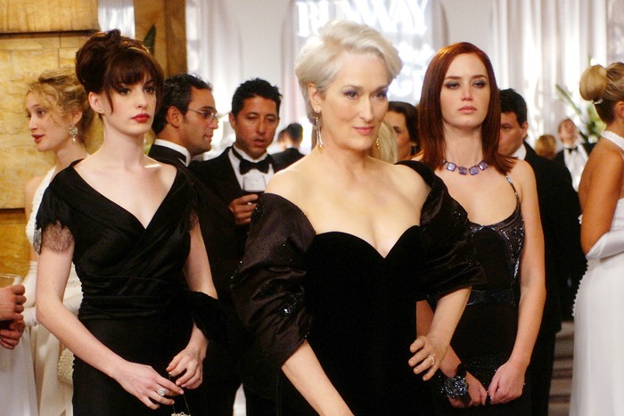 Meryl Streep, Anne Hathaway and Emily Blunt in The Devil Wears Prada, stood together all wearing black dresses