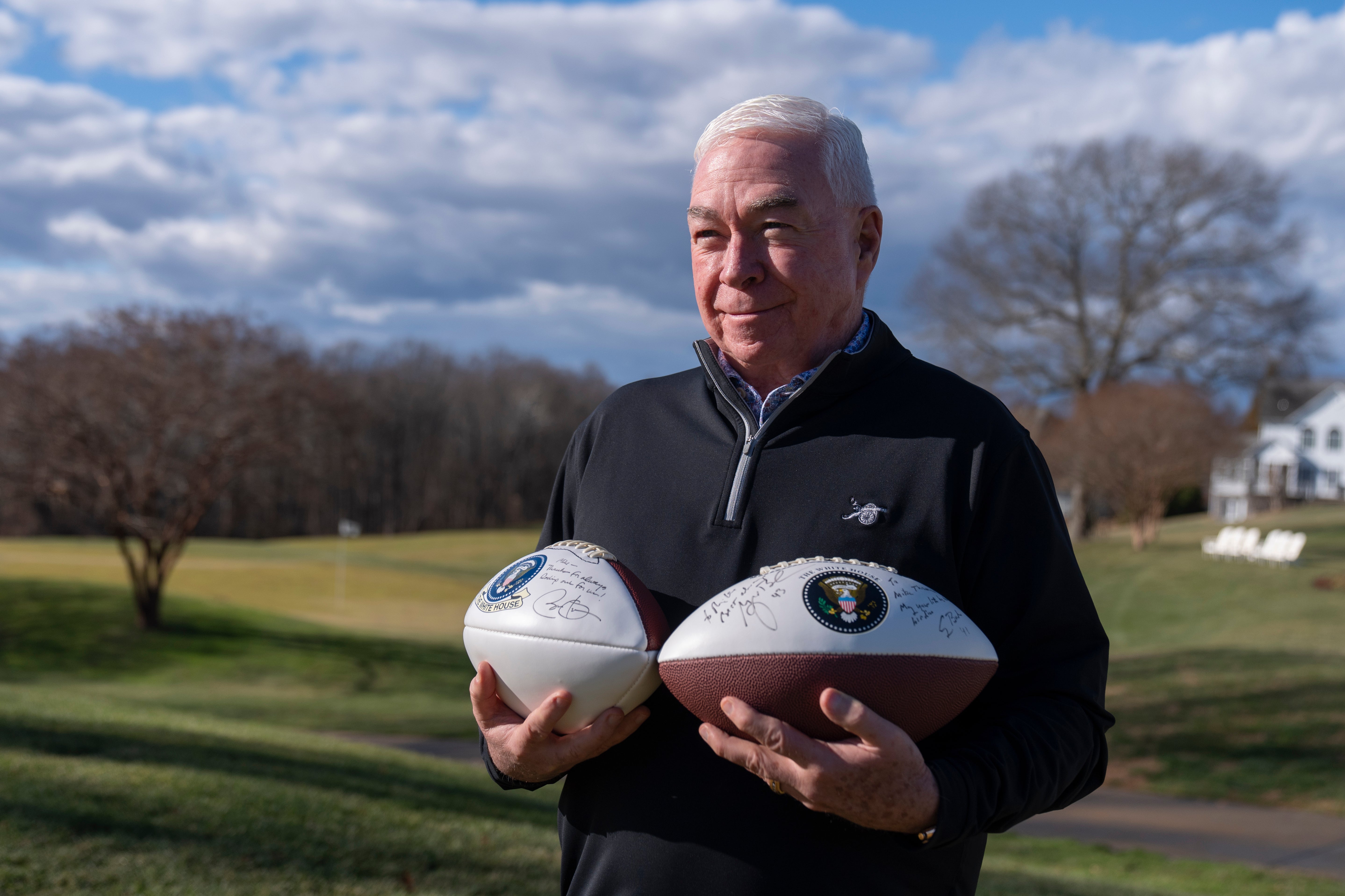 Michael Thomas, the former manager of the Courses at Andrews at Joint Base Andrews, stands with footballs autographed by several former presidents, Friday, Dec. 19, 2025, in Lothian, Md. (AP Photo/Mark Schiefelbein)