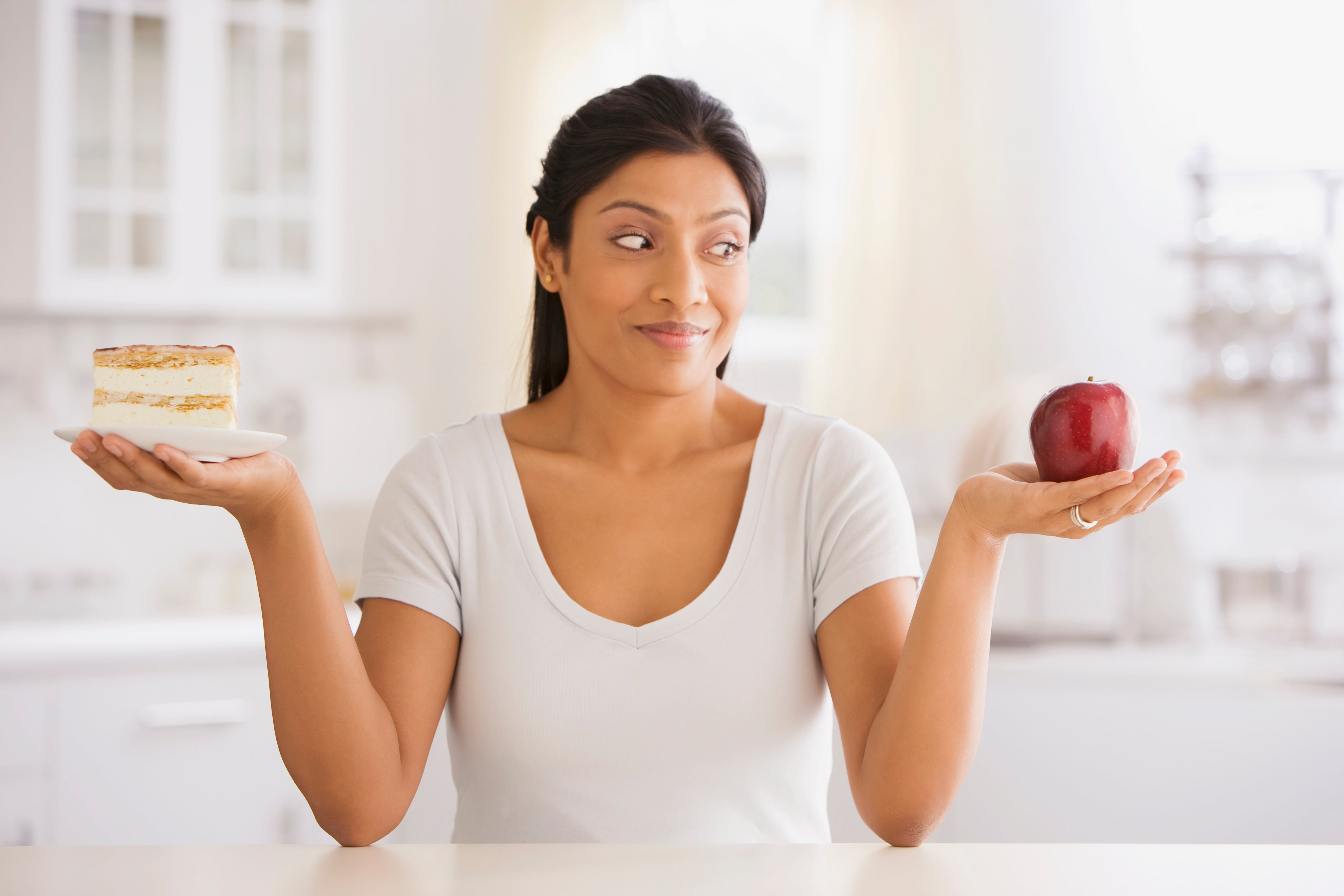 Woman choosing apple over cake