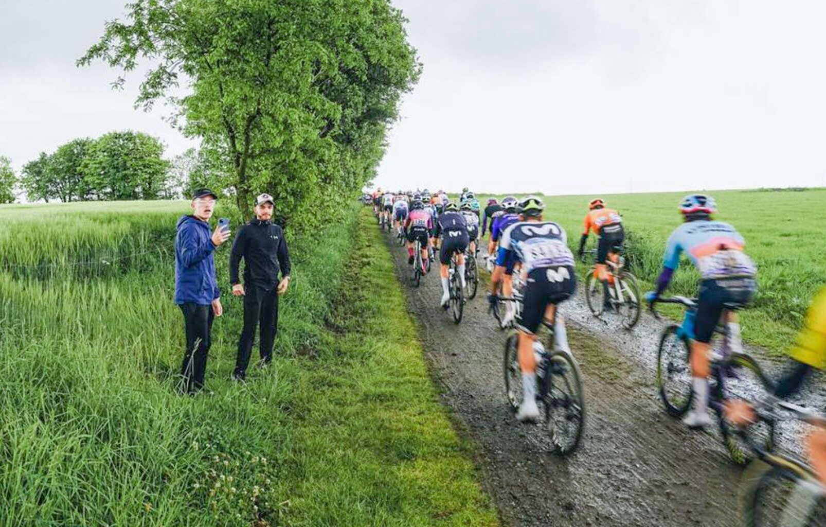 Riders pass by fans on a dirt 'ribin' sector at the 2025 Tro-Bro L&eacute;on